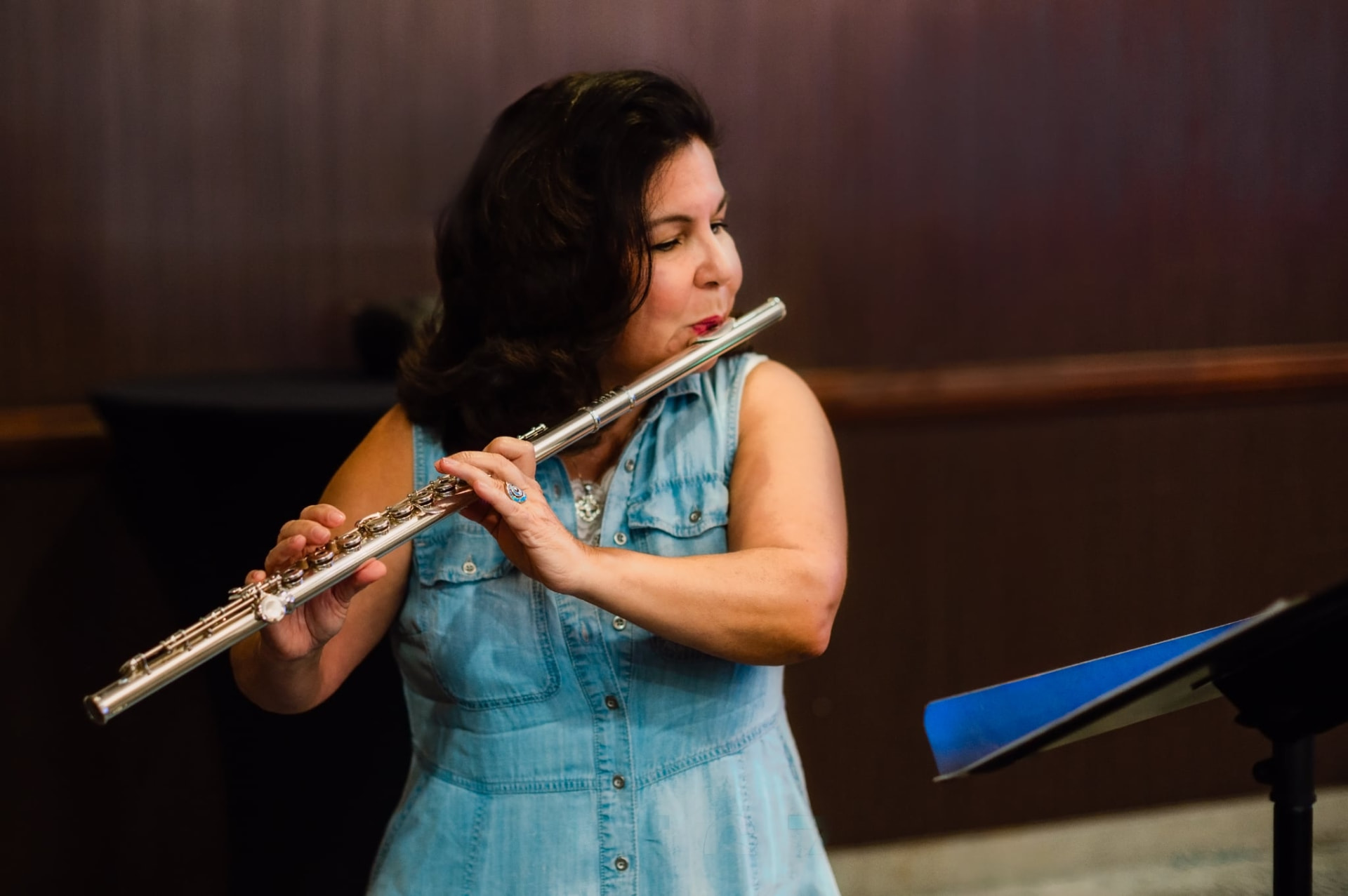 Cynthia holding a flute and sheet music for Mussorgsky's Night on Bald Mountain.